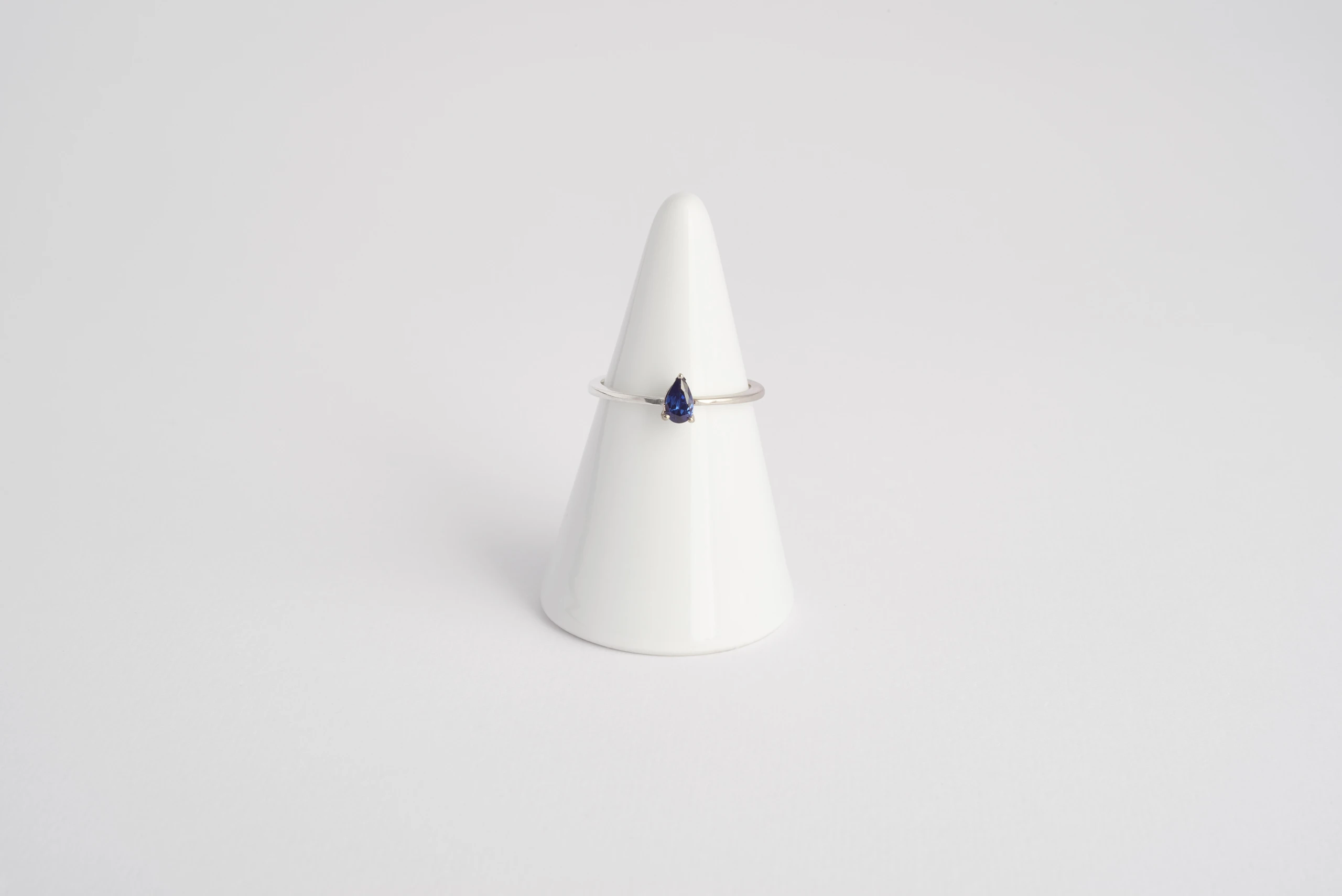 Anello Kai in oro bianco 18kt rodiato con zaffiro blu taglio goccia e gambo a mezza fede, Monica Candido Gioielli Milano - 1
